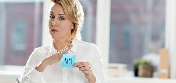 Female manager holding up a post it note with 'No' written on it