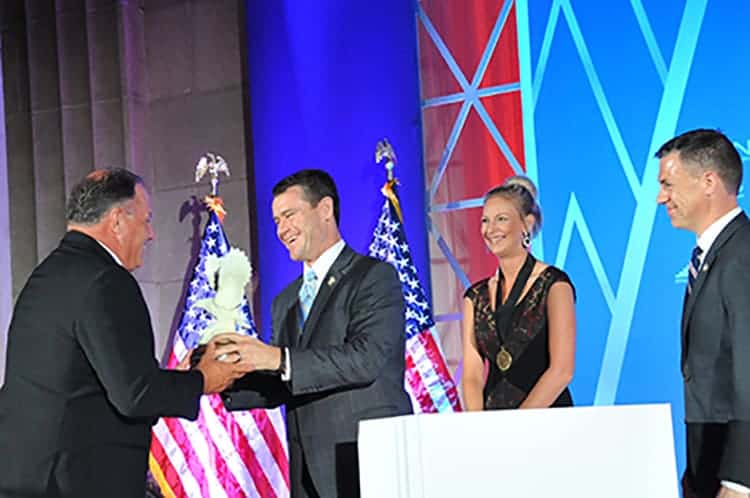An award winner accepts an award on stage at this national convention.