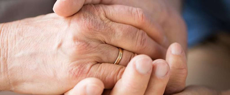 Close up of couple holding hands during cancer treatment