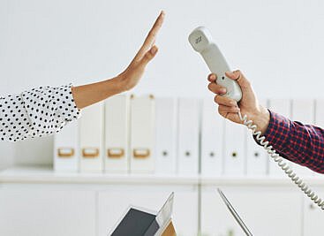Holding a phone up with a hand refusing to take the call