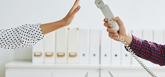 Holding a phone up with a hand refusing to take the call