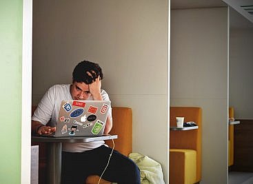 management consultant sitting at laptop frustrated by the recruitment process