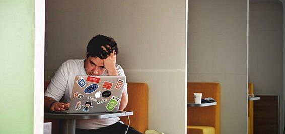 management consultant sitting at laptop frustrated by the recruitment process