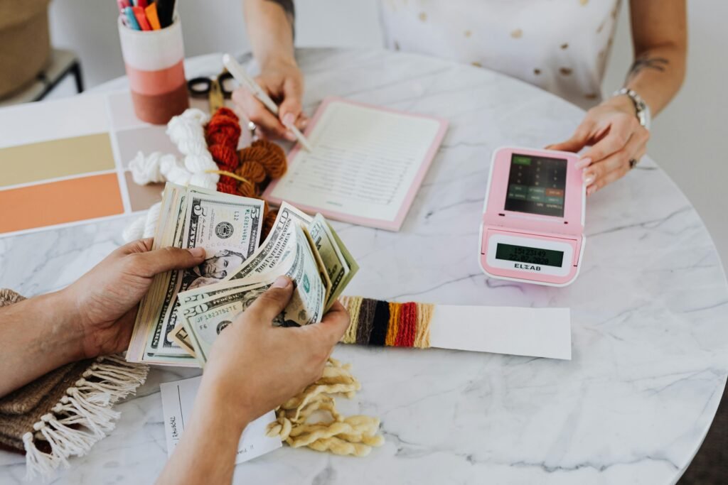 Hands counting cash with a loan application and receipt printer on a table, representing instant cash loans and fast approval processes.
