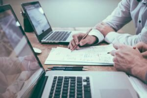 Two people working together at a desk with laptops and documents, focusing on financial planning and analysis. Personal Finance softwware