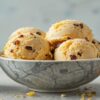 Homemade-Cheese-and-Pickle-Ice-Cream-A-Uniquely-Unconventional-Fusion-featured-image-637x1920w-bowl-of-cheese-and-pickle-ice-cream-with-jar-of-branston-pickle-and-sliced-cheese-frosted-fusions