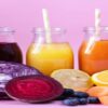 New-Year-Fresh-Vibes-Nourish-Your-Body-With-Healthful-Smoothies-featured-image 200x600w 5 smoothies-lined-up in glass jars straws different-colours-with-fresh-fruit and lilac background-frosted fusions