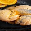 Tiger-Tail-Ice-Cream-The-Sweet-And-Bold-Canadian-Classic-featured-image-830x2450w-top-view-of-orange-ice-cream-with-swirls-of-black-with-licorice-and-fresh-orange-slices-frosted-fusions