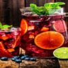 Homemade-Sangria-Ice-Cream-A-Taste-Of-Spain-featured-image-200x620w-jug-and-glasses-filled-with-sangria-and-fresh-fruit-scatter-around-frosted-fusions