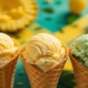 Rum-In-The-Sun-–-Caribbean-Inspired-Ice-Cream-Recipes-Featured-Imaeg-3-ice-cream-cones-with-tropical-background-with-fresh-pineapple-mango-and-coconue-and-a-botlle-of-Rum-Frosted-Fusions