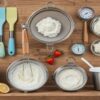 Top-10-Essential-Tools-For-Homemade-Ice-Cream-Making-–-featured-image-flat-lay-of-spatulas-whisks-sieves-bowls-thermometer-blender-and-freezer-tubs-Frosted-Fusions
