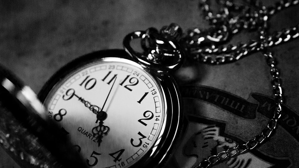 fotografia in scala di grigi di un orologio da tasca analogico