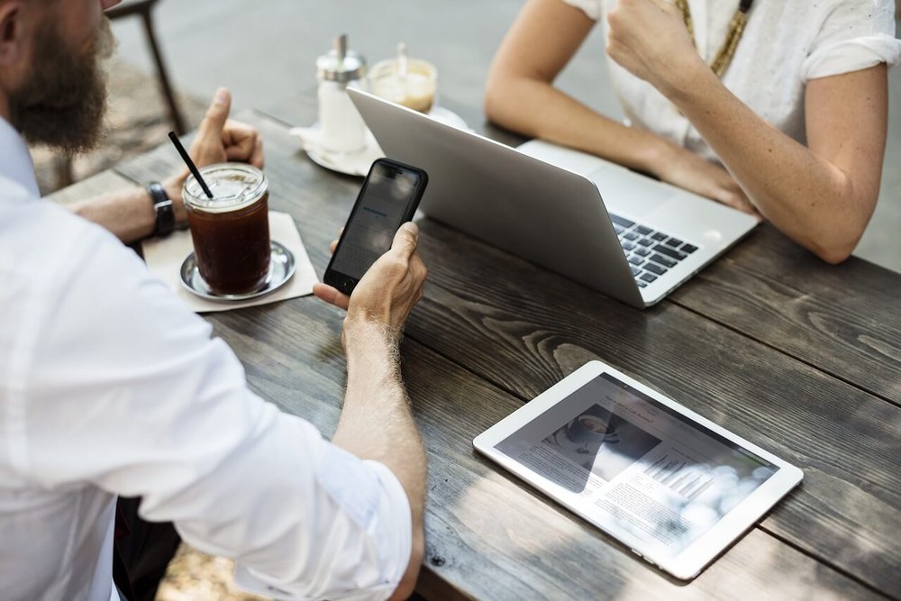 A man and a woman conducting one of their sales meetings across from each other at a table.