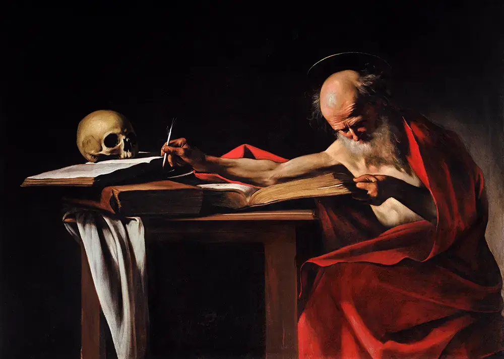 San Jer&oacute;nimo, con el torso desnudo y un manto rojo, se inclina sobre un escritorio para escribir la traducci&oacute;n de la Biblia, iluminado por una intensa luz lateral en una obra de Caravaggio.