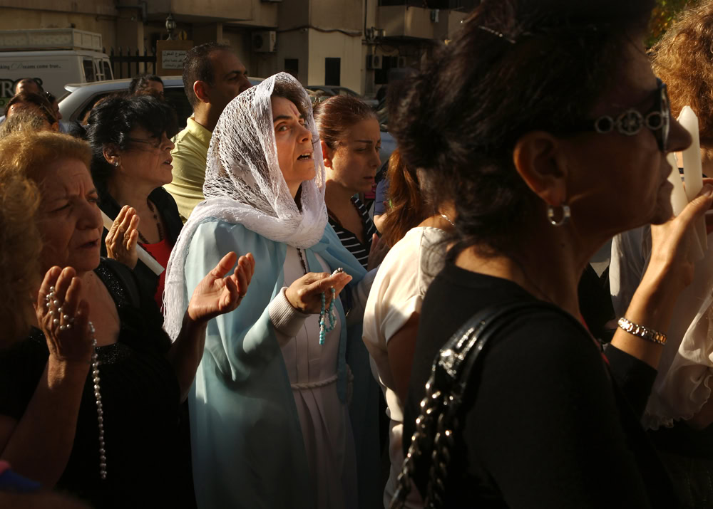 A Lebanese Maronite Christian woman dressed as Virgin Mary prays during a procession marking the month of Virgin Mary in the town of Jdeideh, north-east of Beirut, on May 21, 2016. / AFP PHOTO / PATRICK BAZ