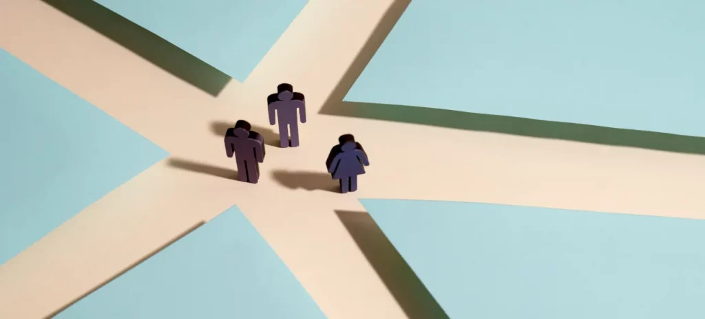 Perspektivwechsel: Ein Erfolgsfaktor, um Veränderungen richtig einzuschätzen. Drei Figuren stehen an einer Weggabelung, die in verschiedene Richtungen führt – Sinnbild für Perspektivwechsel und kluge Entscheidungsfindung.