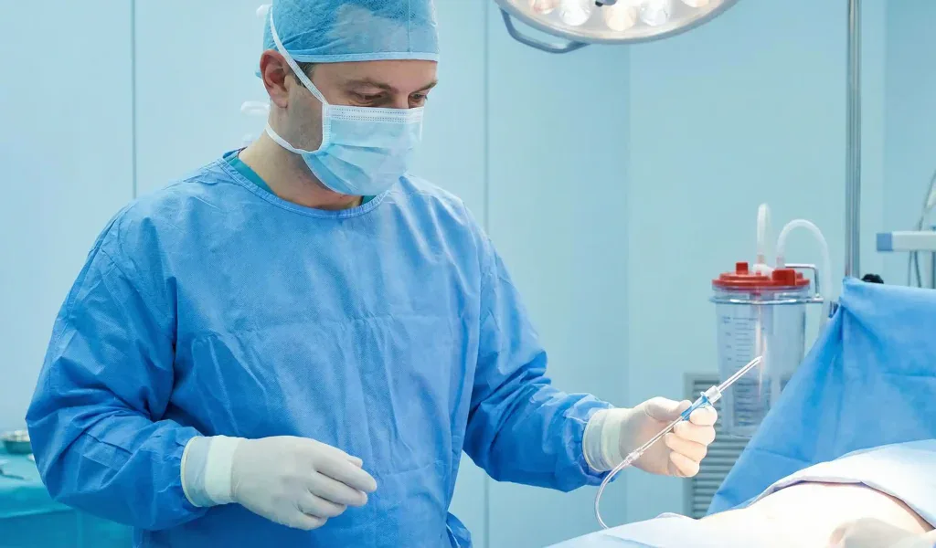 Liposuktionschirurg im Operationssaal mit Kanüle