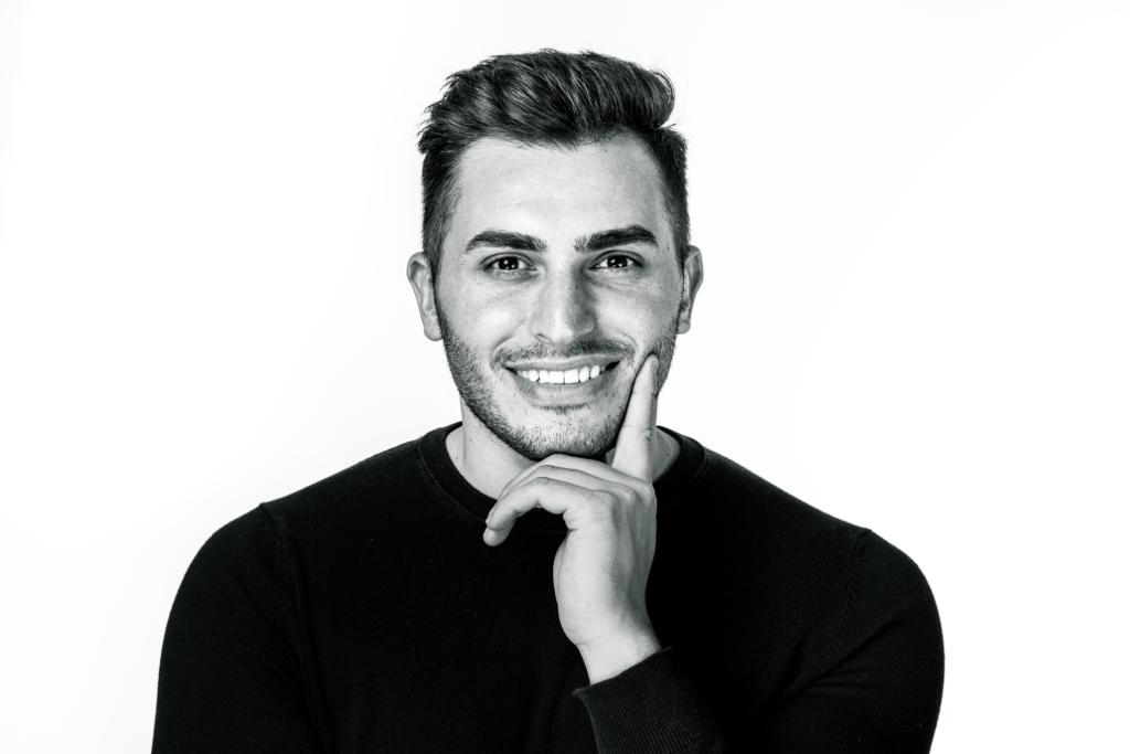 Egzon, Gründer Dubai Visa Schweiz in die Kamera lachend auf seinem Profilbild, schwarz-weiß.