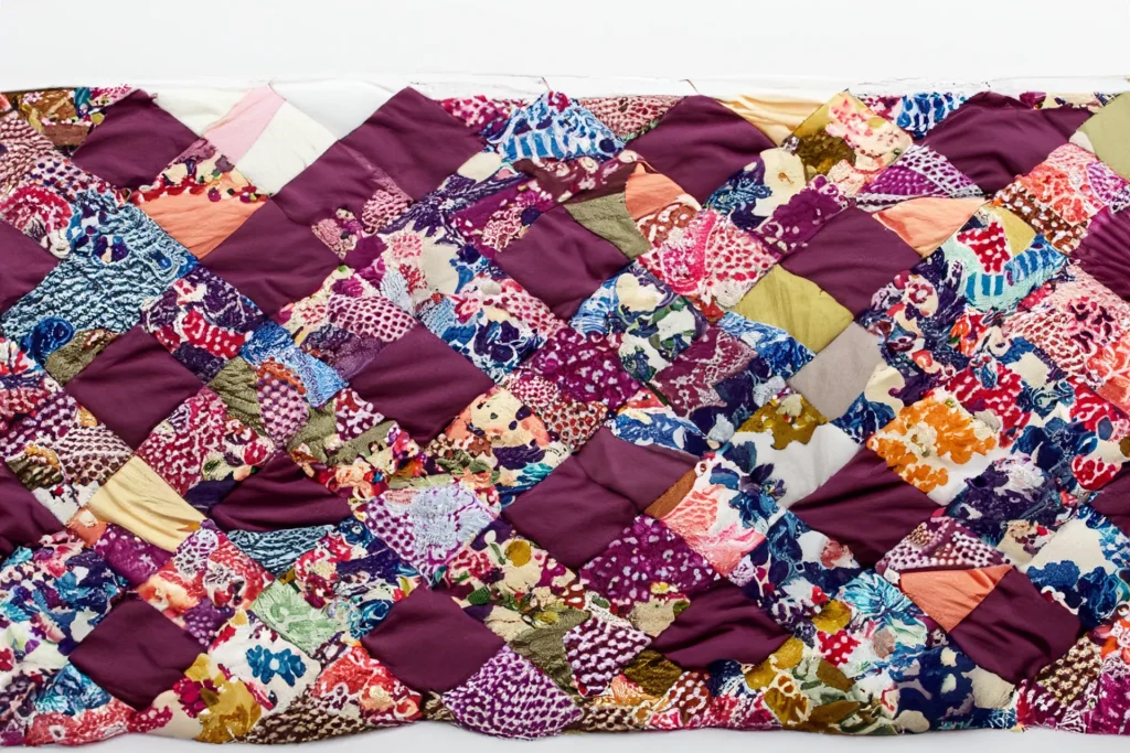 Quilting -  a decorative piece of bedding or wall hanging made from small pieces of fabric sewn together in batted layers