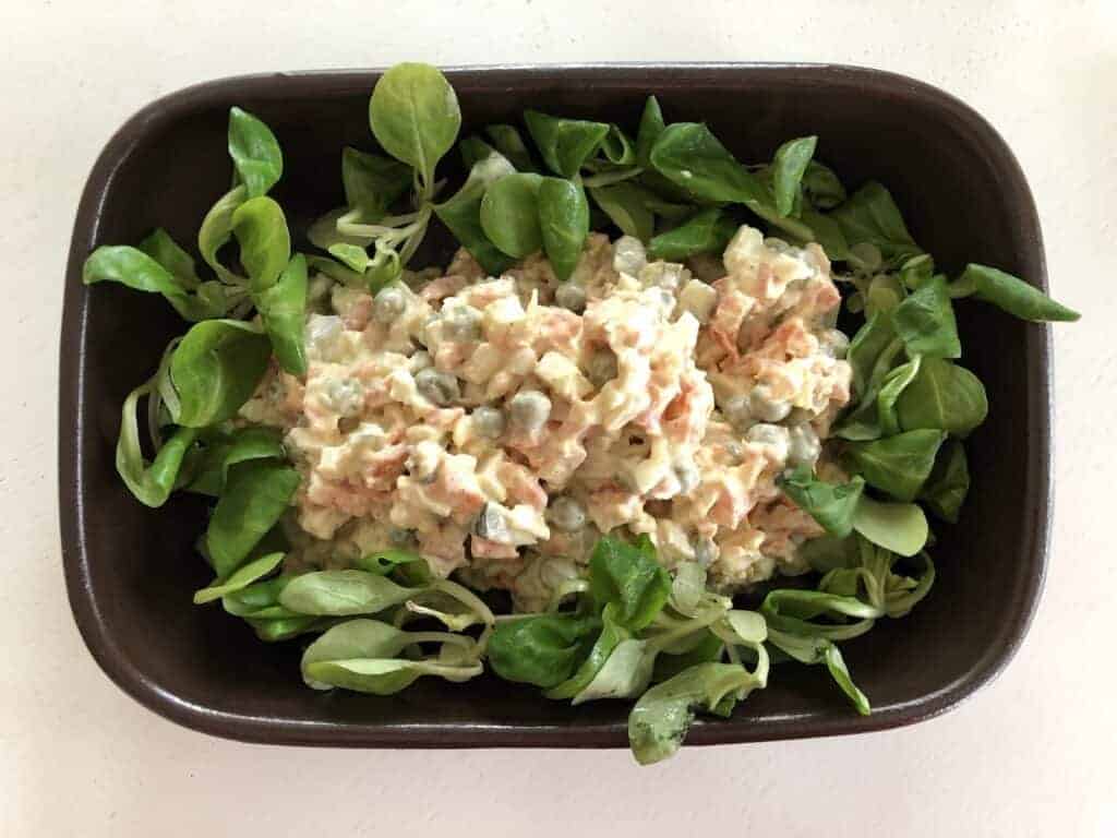 Polish vegetable salad in a black bowl.