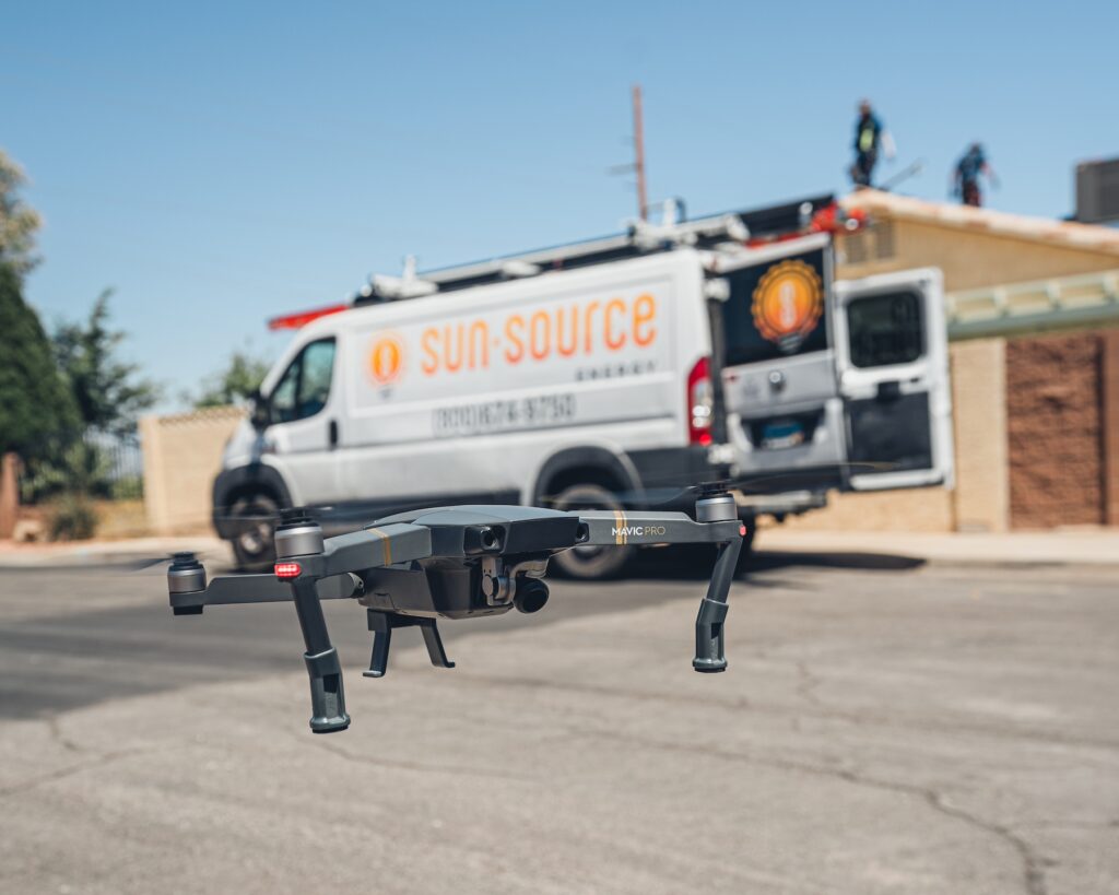 A drone with a Sun Source Energy installation van behind it.