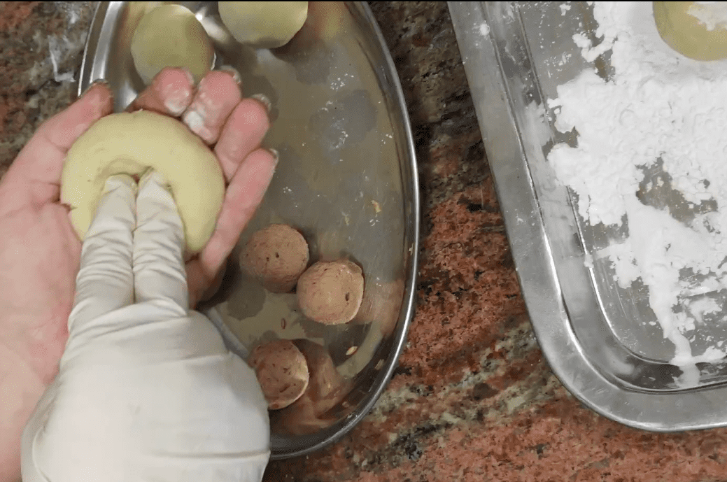 Forn a hole in the pyzy dough.