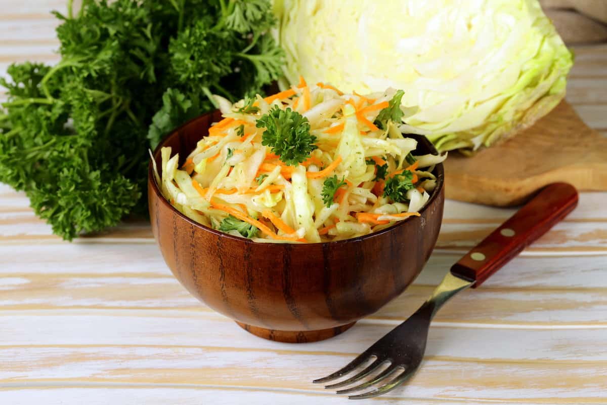 Polish coleslaw in a wooden bowl with a fork.