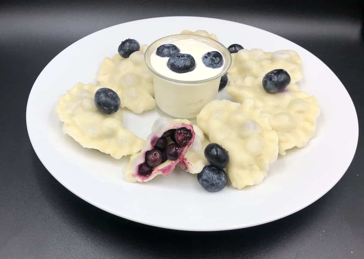 blueberyy pierogies on a white plate.