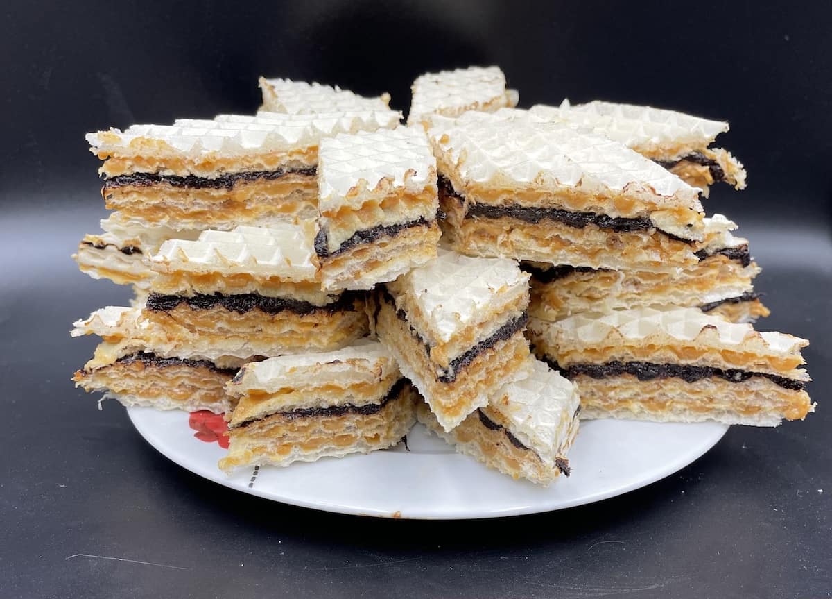A plate with a stack of Polish wafer cake pastries on it.