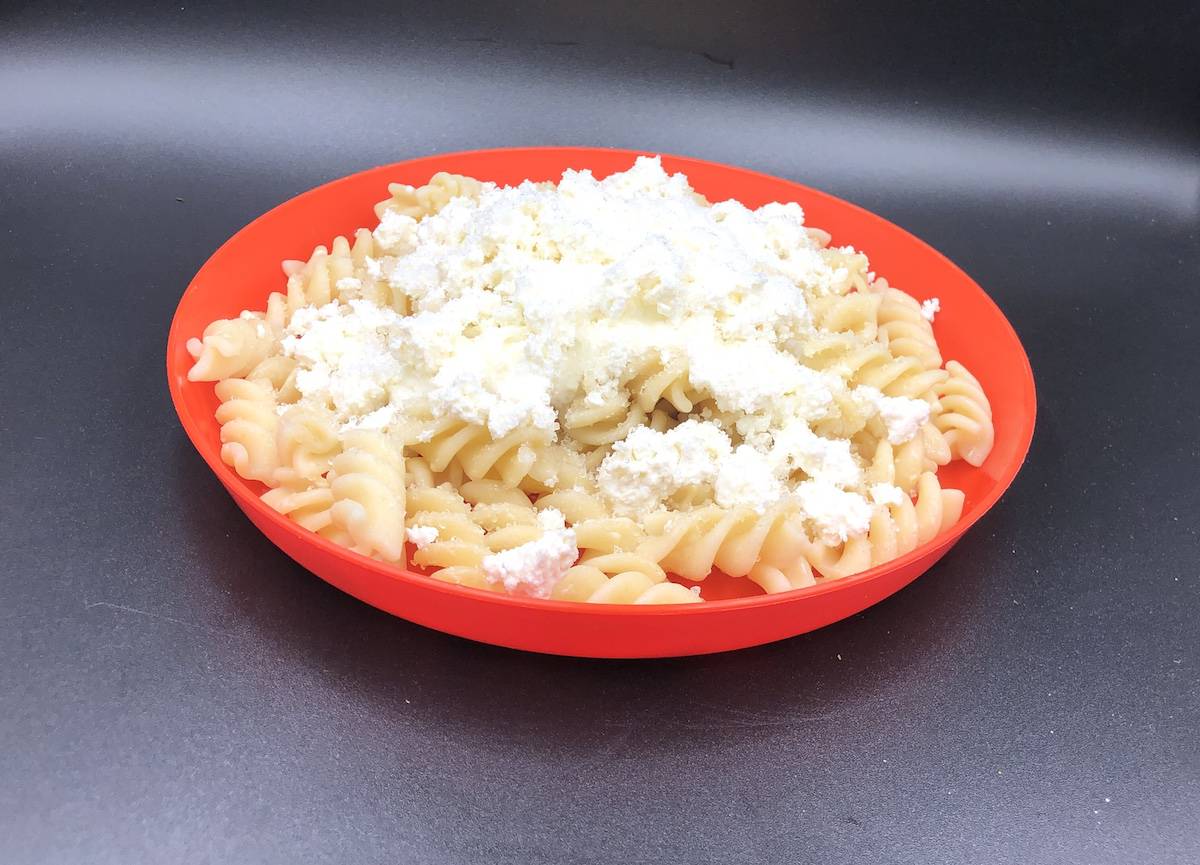Polish noodles and cottage cheese in an orange bowl.