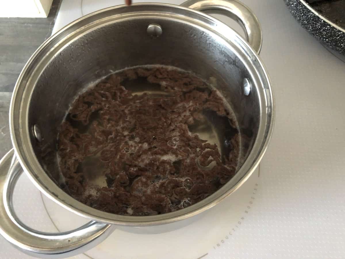 Traditional Polish cuisine featuring a pot full of chocolate in a pan on top of a stove.