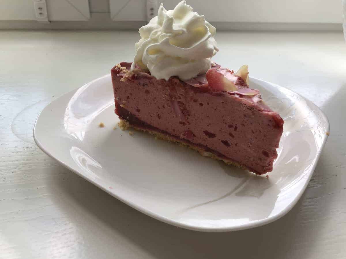 A slice of no bake plum cake on a white plate.