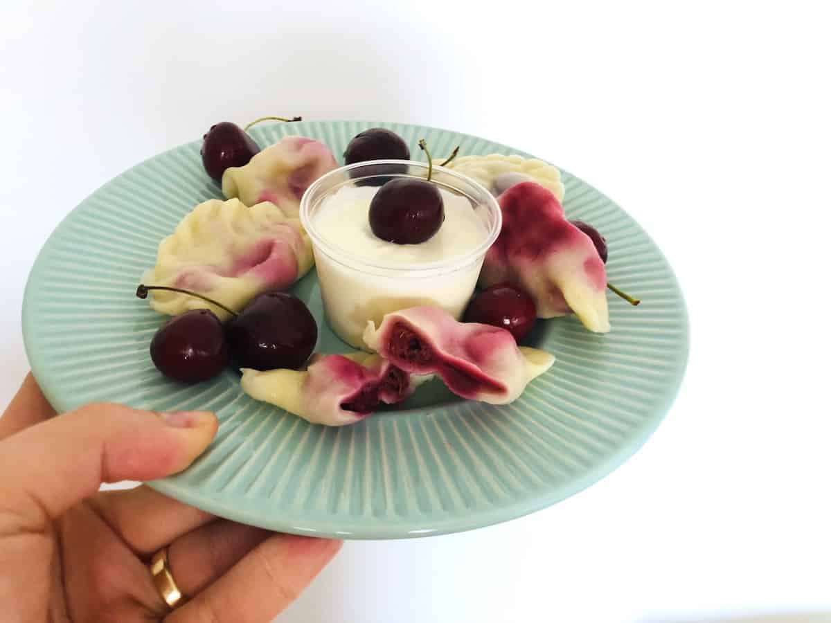 Polish cherry pierogi in a blue plate.