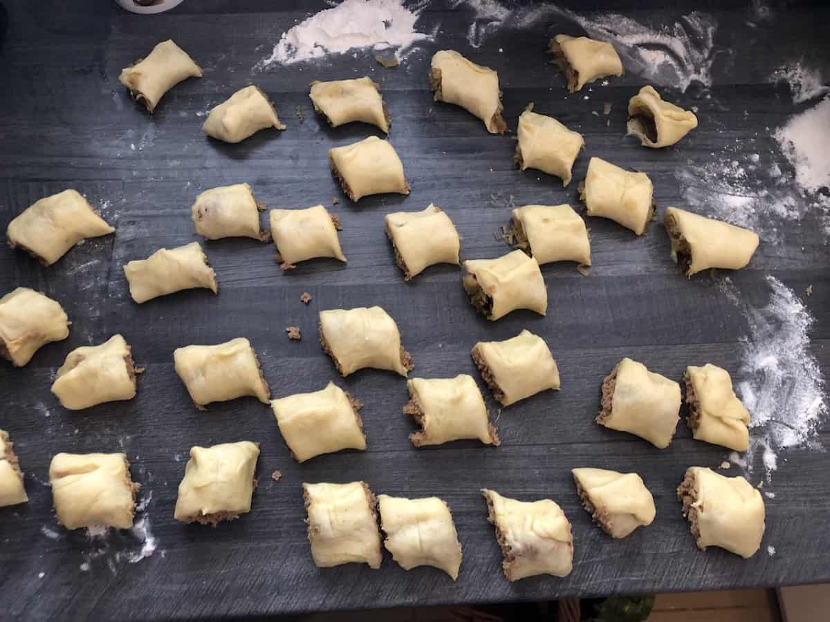 A tray with a lot of pastry dough on it, used for making Polish Sauerkraut Pies - Paszteciki Z Kapusta i Grzybami.