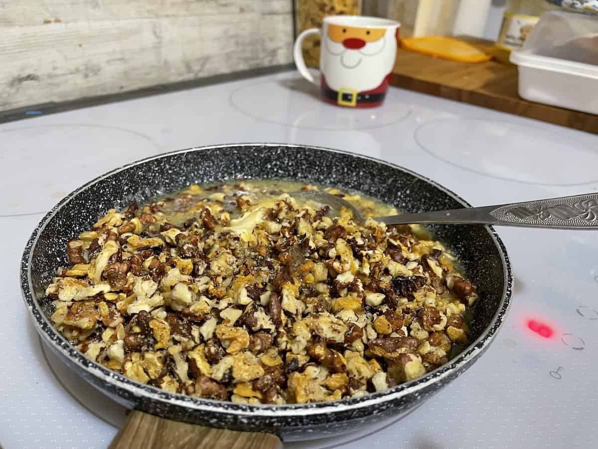 Walnuts in the honey in a pan.