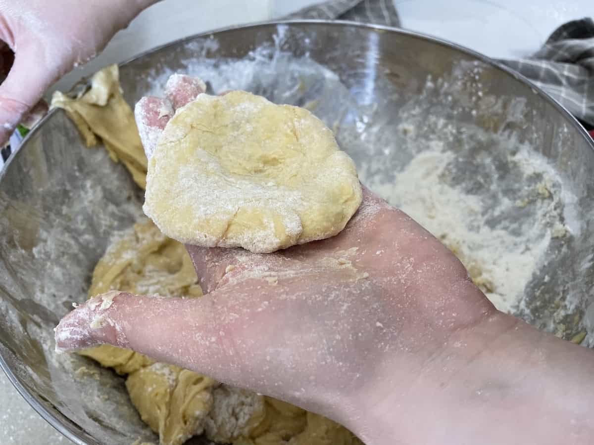 Flatten the doughnut ball in your hand.