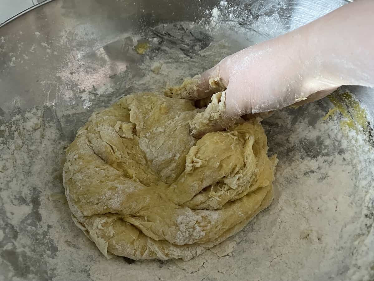 Hand kneading flour into a dough.