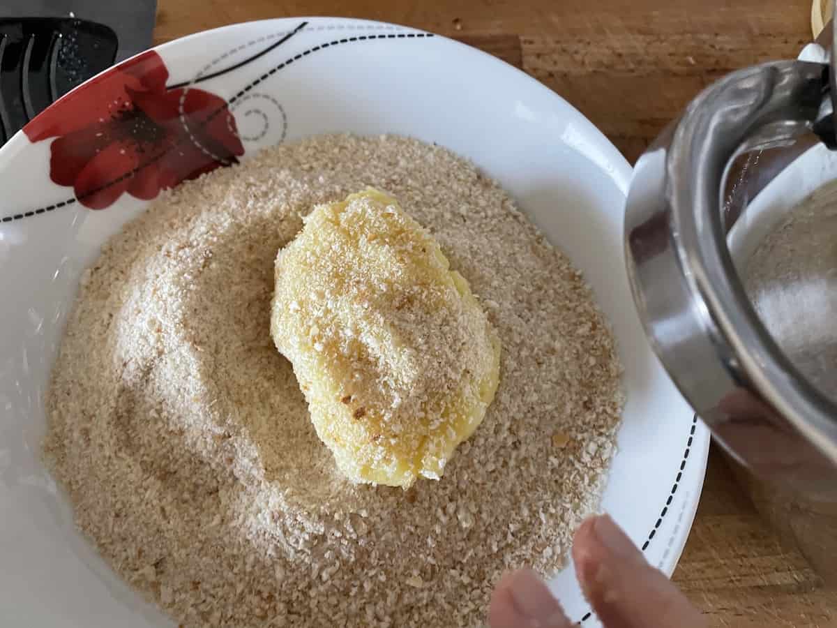 Coating the potato mash with breadcrumbs - other side.