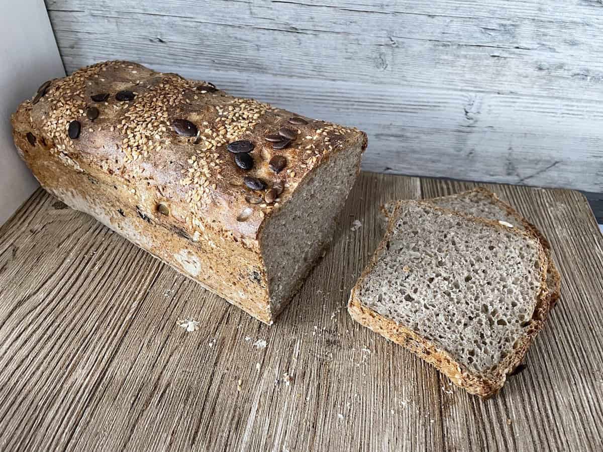 A loaf of Polish sourdough multigrain bread sitting on a wooden table.