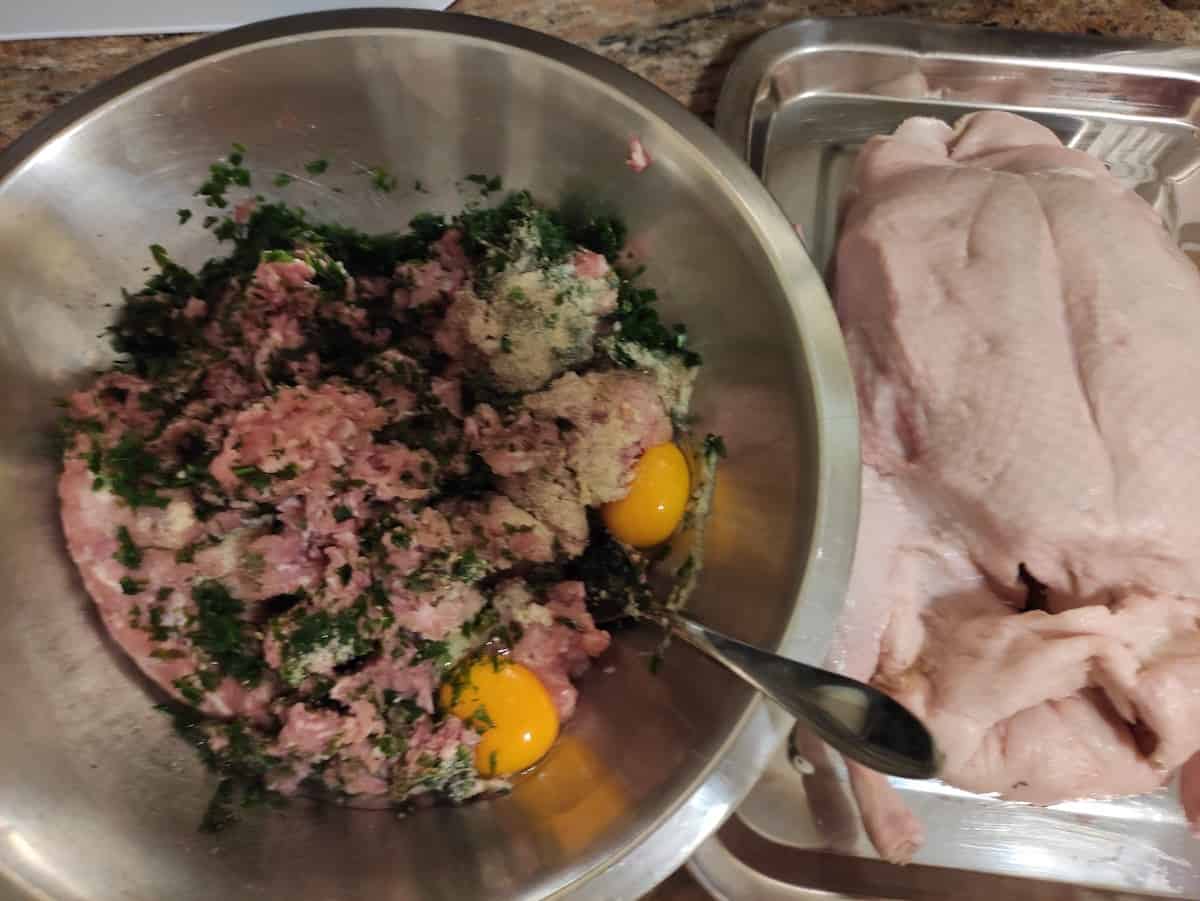 Ground meat filling in a pot next to the gutted duck.