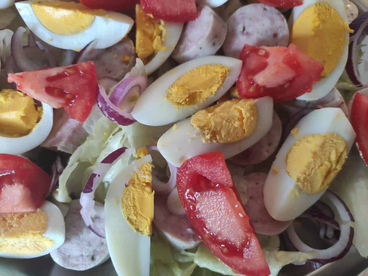 Tomato and egg wedges on kielbasa salad.