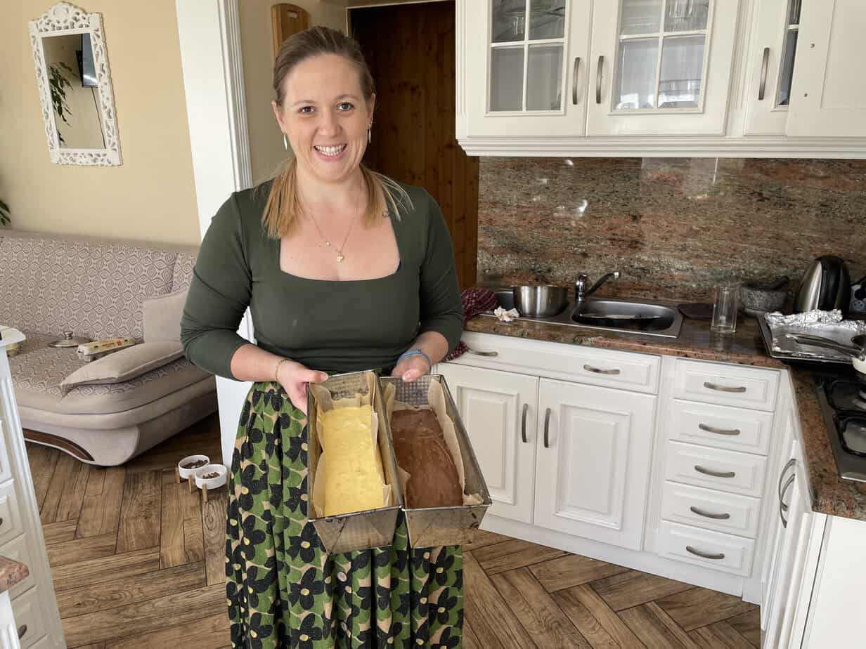 Woman holding a loaf of unbaked Metrowiec dough in a kitchen.