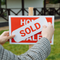 Sold sign being placed on a home during the selling process
