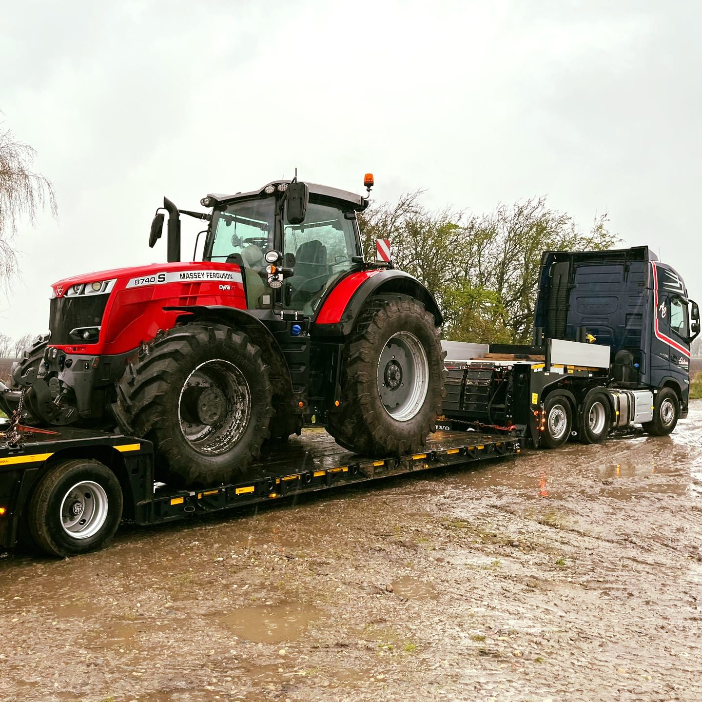 Massey Ferguson-traktor på trailer bag en lastbil fra Anker Christensen