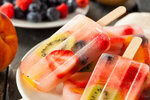 Fun-Easy-Homemade-Ice-Lollies-Popsicles-—-The-Perfect-Summer-Treat-image-9 couple of fruit filled ice lollies with fresh fruit in the background Frosted fusions