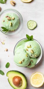 Benefits-Of-Using-Superfoods-In-Homemade-Ice-Creams-image-6-rotated-bowl-of-ice-cream-with-slices-of-lemon-half-avocado-pistachios-and-fresh-leaves-frosted-fusions