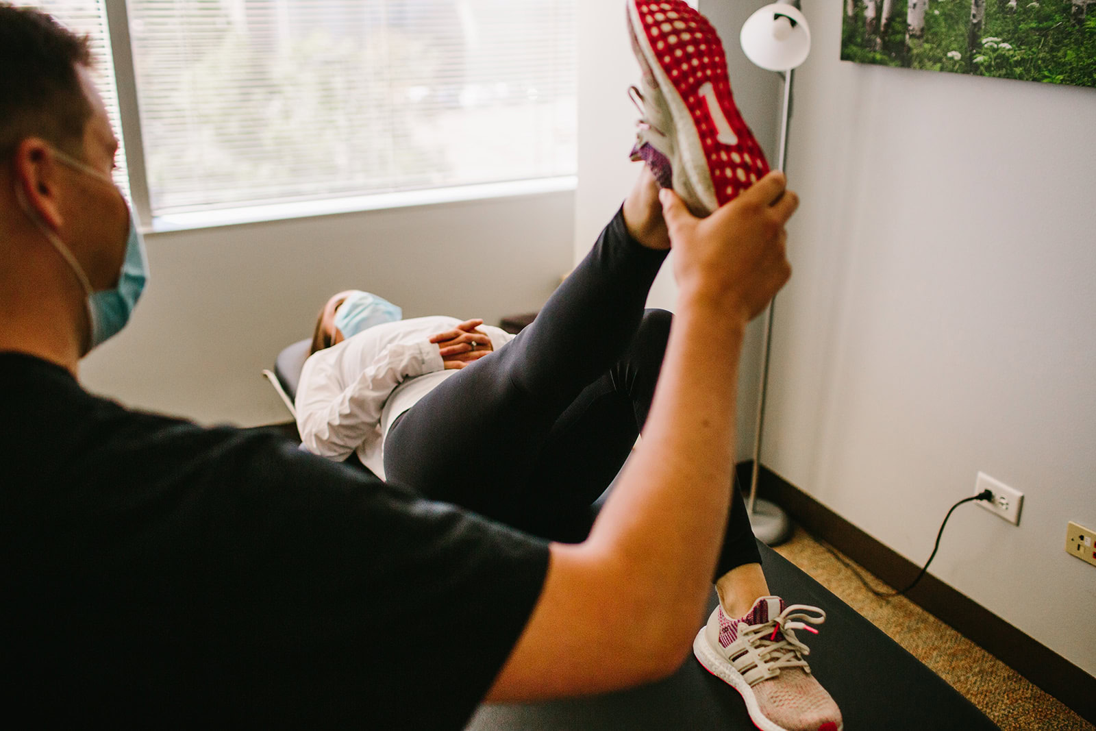 physical therapist doing knee rehab exercise with female patient