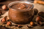 A Quick N Easy Homemade Nutella Ice Cream Recipe image 2 hazelnuts scattered with a jar of chocolate spread frosted fusions