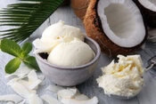 Homemade-Coconut-Ice-Cream-Recipe-image-4-dish-of-coconut-ice-cream-with-coconut-shavings-and-half-a-coconut-to-the-side-frosted-fusions