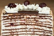 learn-how-to-make-homemade-ice-cream-cakes-image-10-ice-cream-cake-halved-showing-layers-of-ice-cream-and-cake-topped-with-chocolate-cream-and-cherries-frosted-fusions